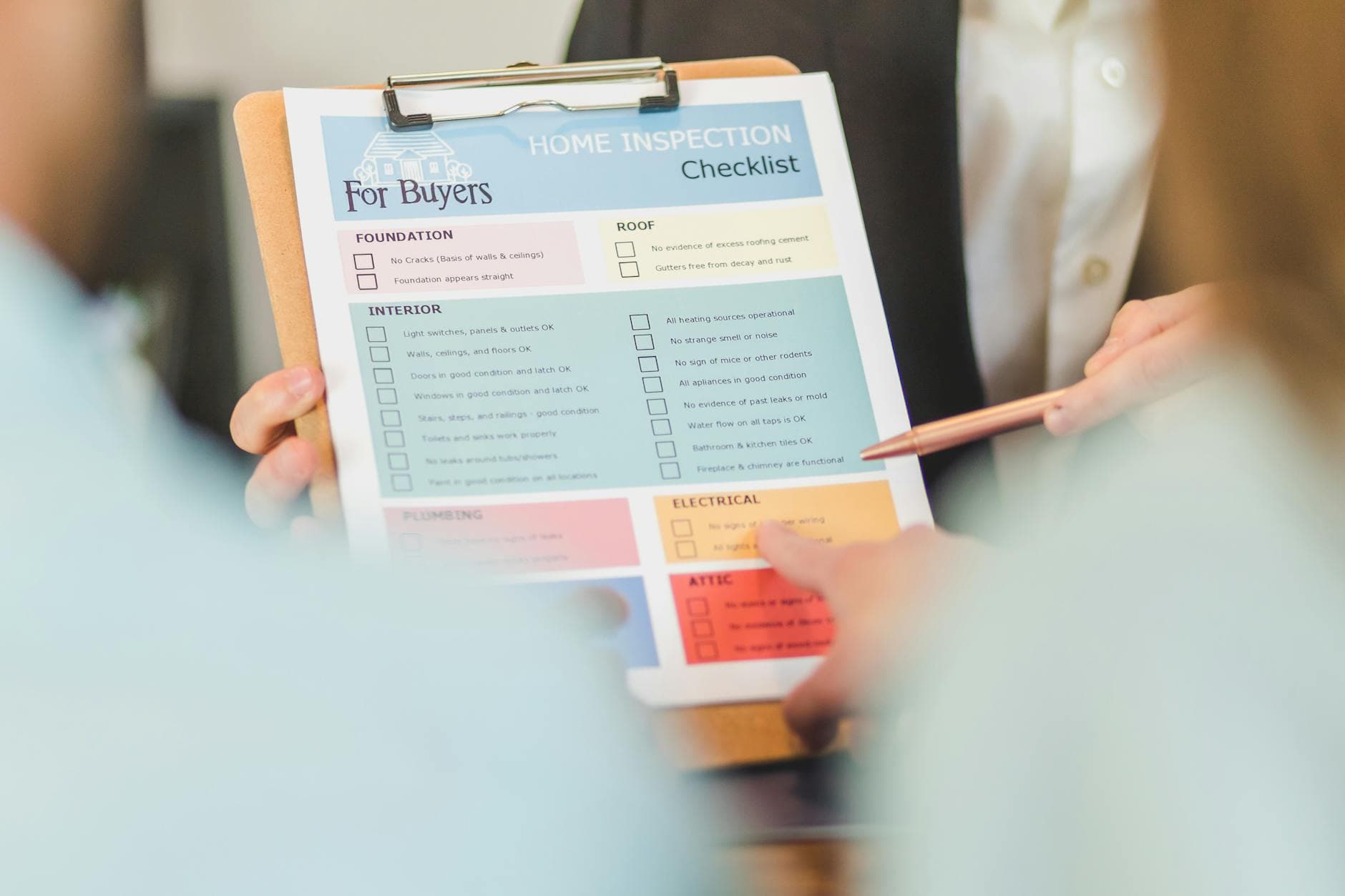 Person holding a checklist clipboard with pen, reviewing inspection form
