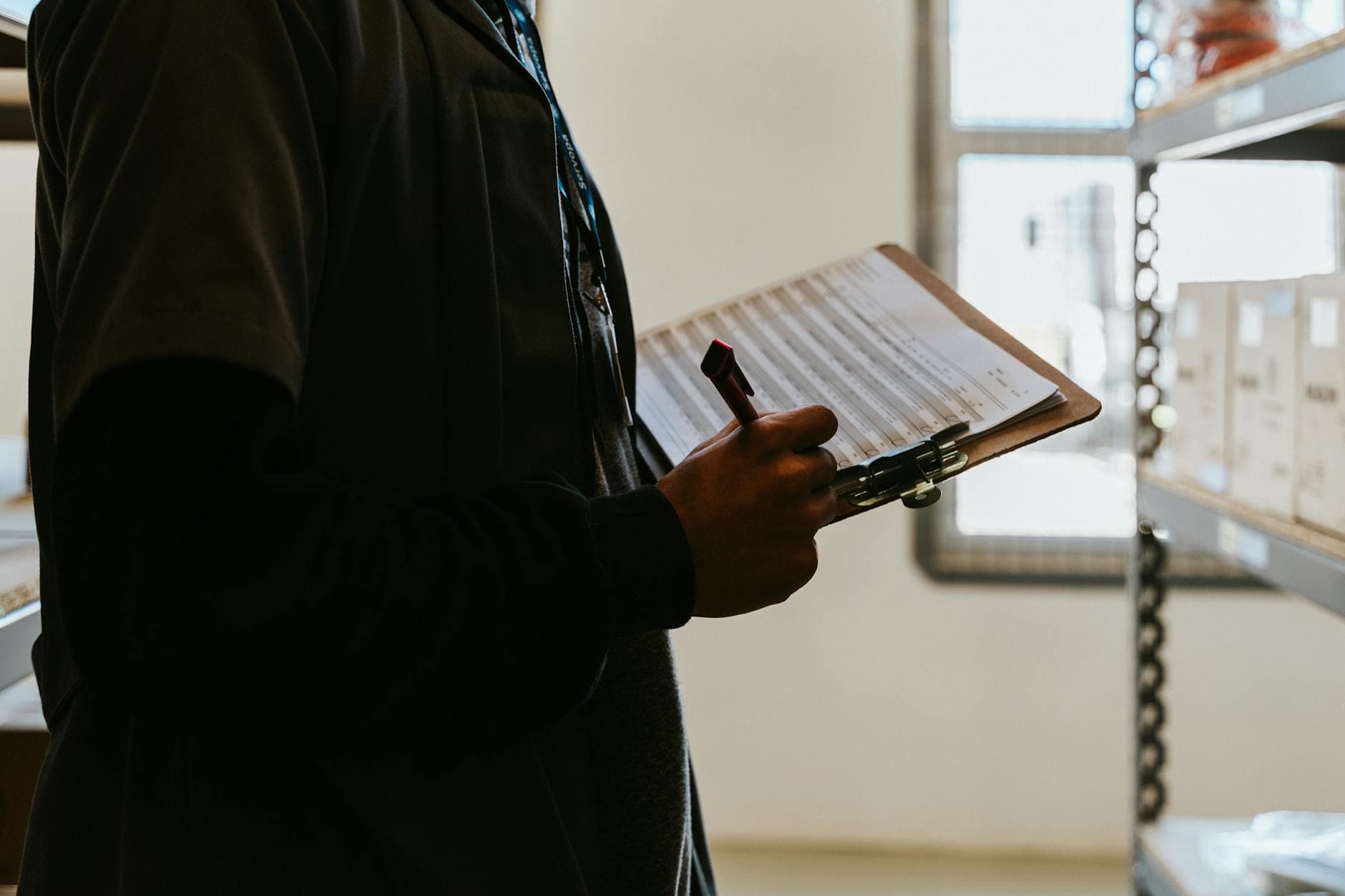 Industrial worker reviewing checklist clipboard in food production warehouse