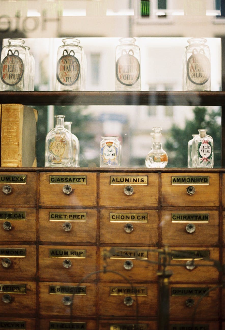Antique apothecary cabinet with glass bottles - the kind of DACH wellness accounts that have sourced Balkan herbs for decades