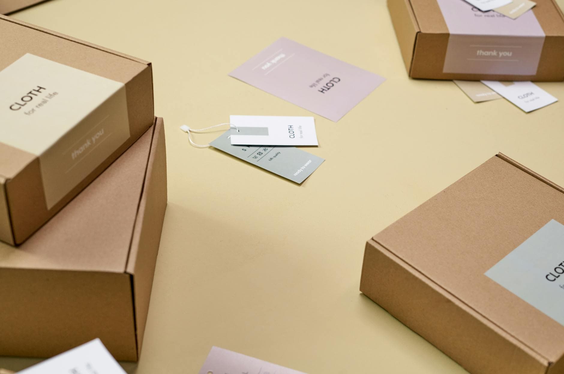 Simple and minimalist cardboard packaging boxes with labels on a yellow surface