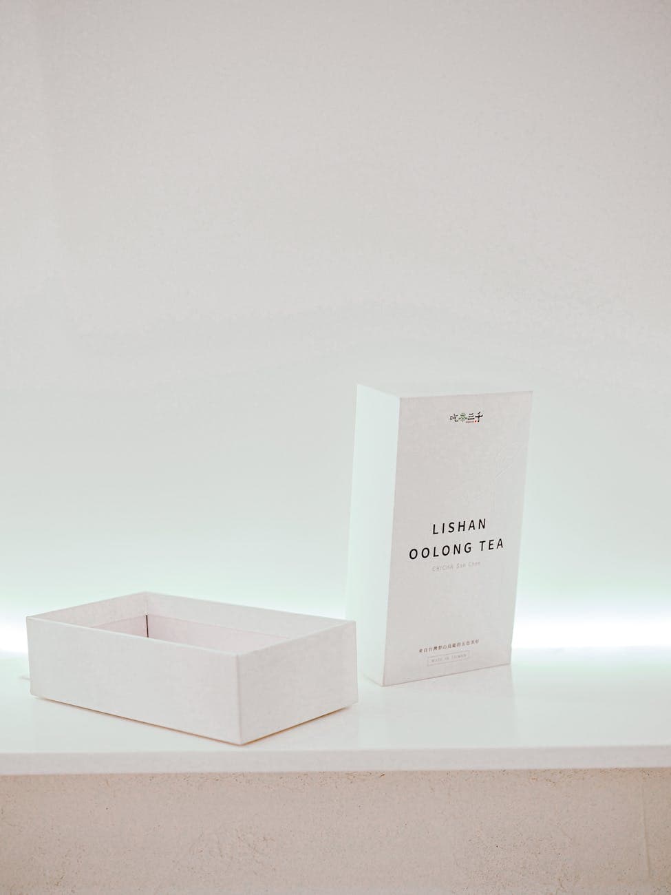 Minimalist white tea packaging box on a light background