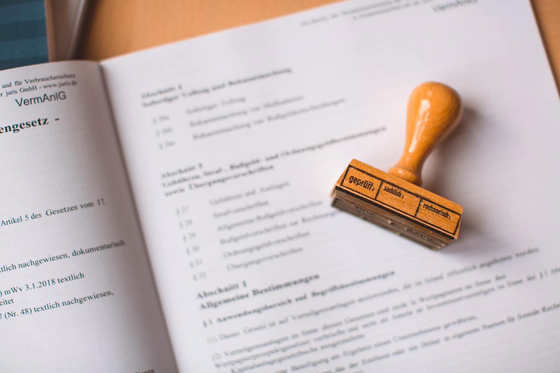 Legal document with wooden verification stamp placed on top, close-up view