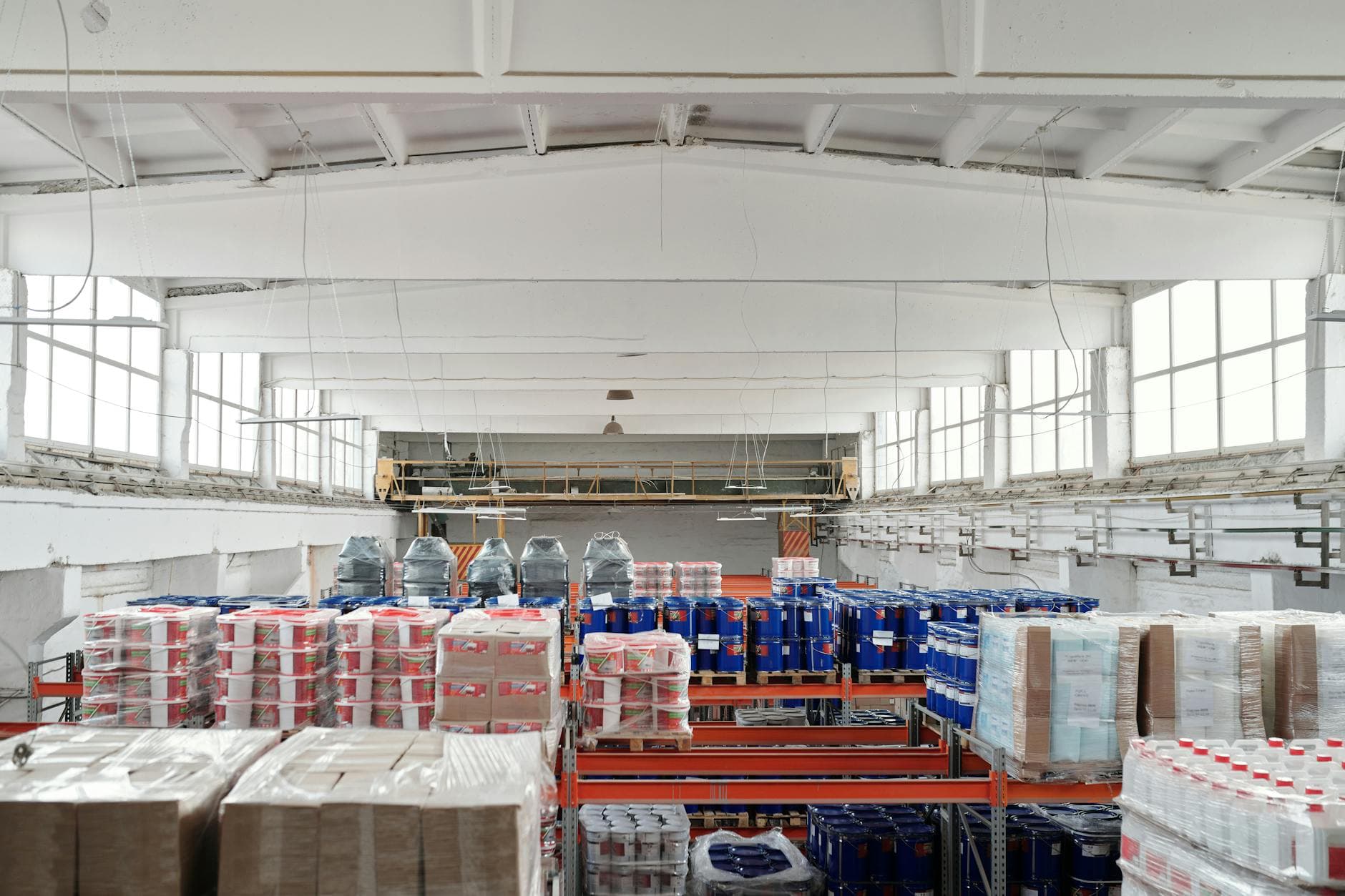 Organized warehouse shelving with cardboard boxes stacked on pallets, showing finished goods ready for distribution