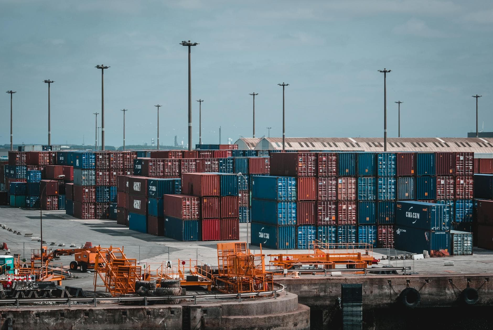 Colorful cargo containers stacked at a busy industrial port showing export logistics from Kosovo to EU markets