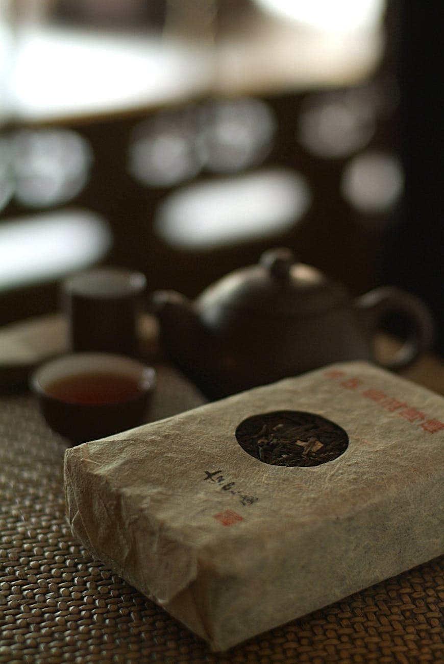 Traditional tea packaging setup showing a rustic teapot and loose-leaf tea packet, illustrating how packaging material choice communicates brand positioning