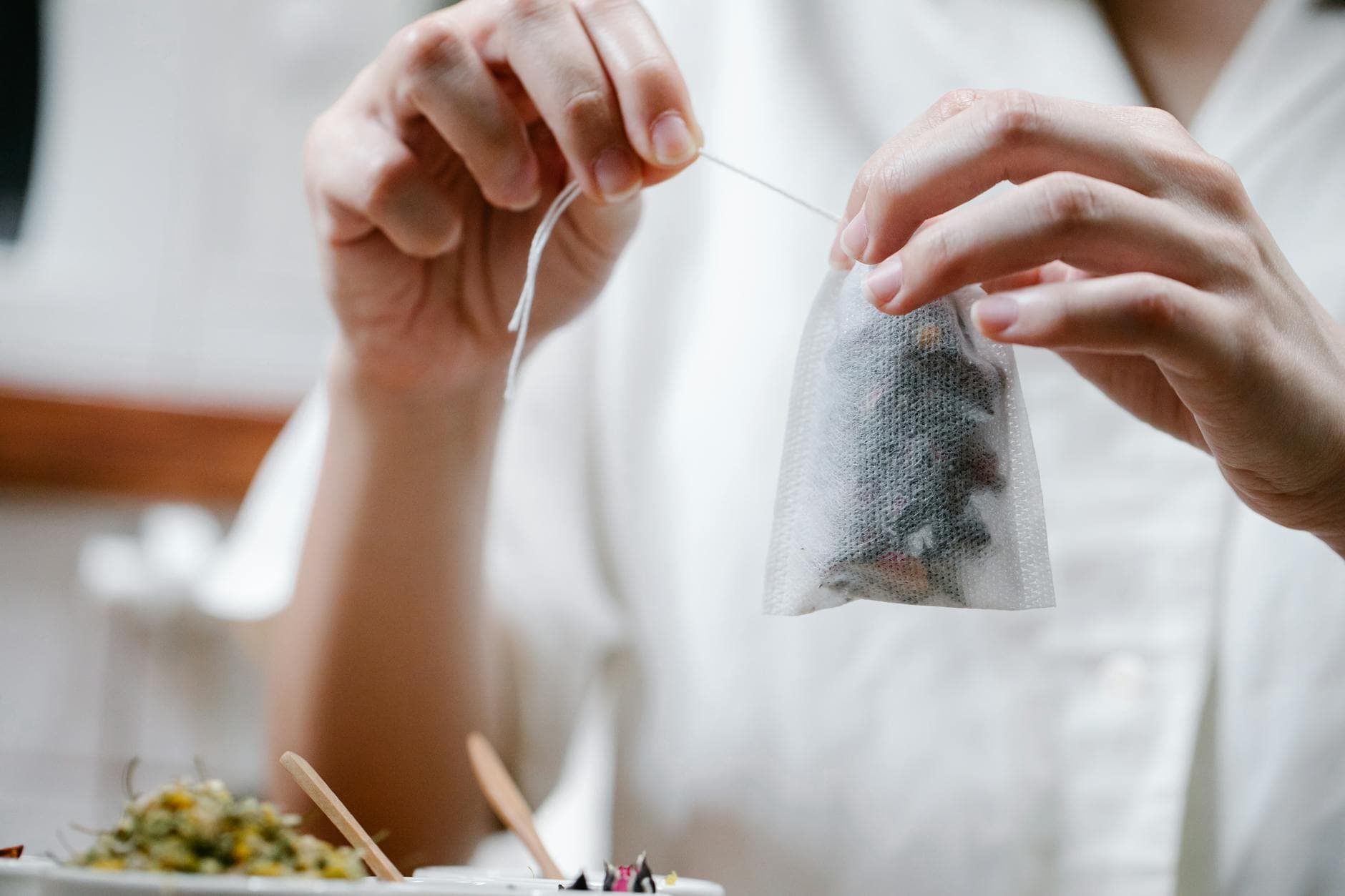 Colorful dried herbal tea blend with rose petals, hibiscus, and fruit pieces showing the bulky low-density material that requires the 64x44mm bag format