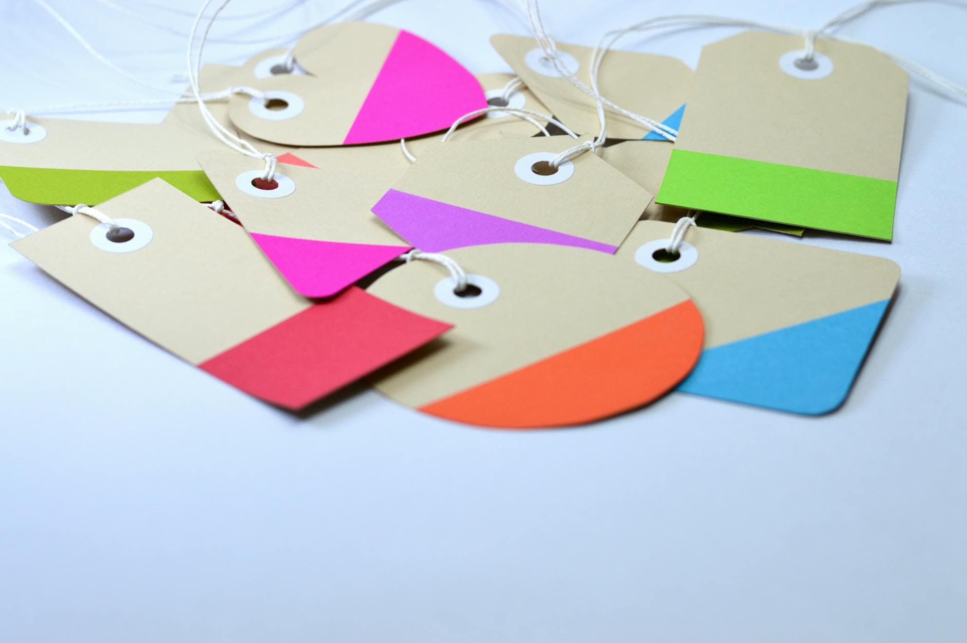 Colorful cardboard tags arranged with strings - the range of stock weights and finishes available for hard tags