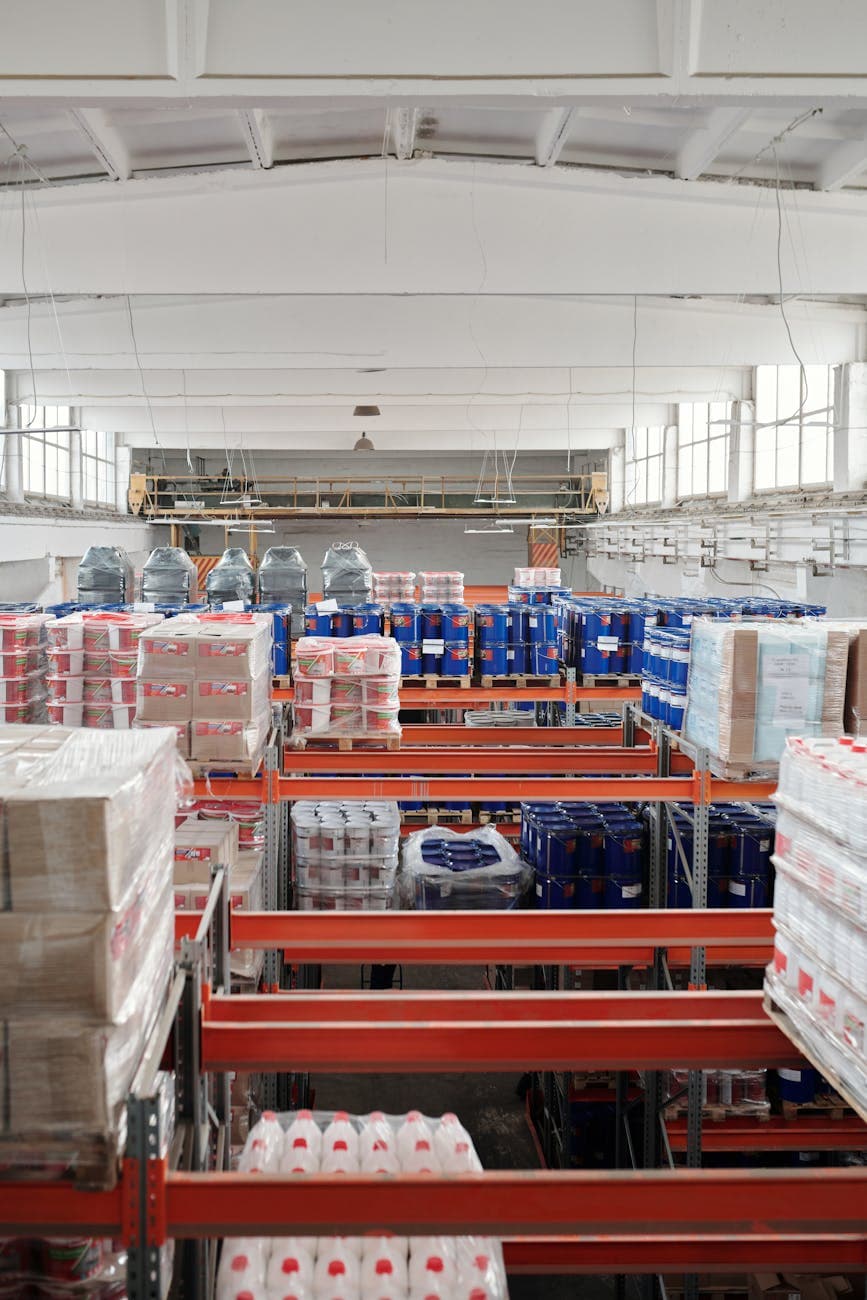 Wooden pallets stacked in a large indoor warehouse, ready for shipment