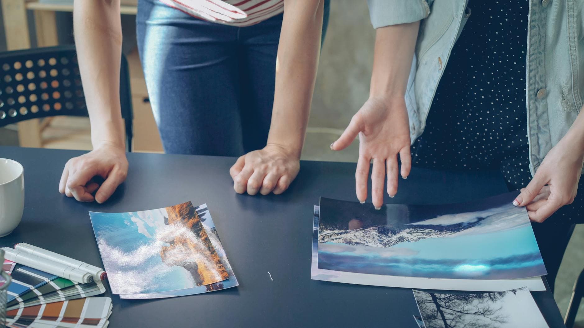 Design team reviewing printed material proofs on a table to check color accuracy