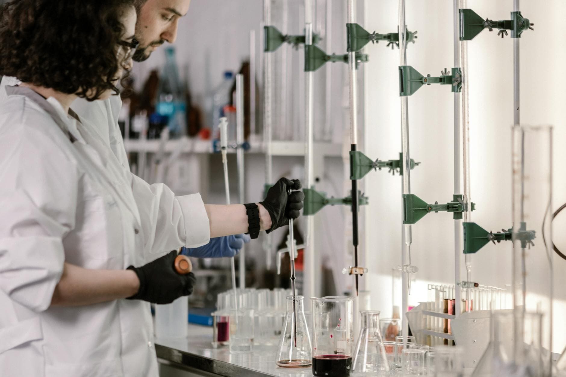 Two scientists in lab coats working together with test tubes in a modern laboratory