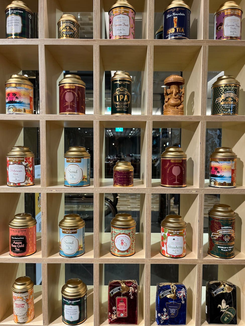 Dekorative Teeblechdosen auf einem Holzdisplayregal in einem Teegeschäft