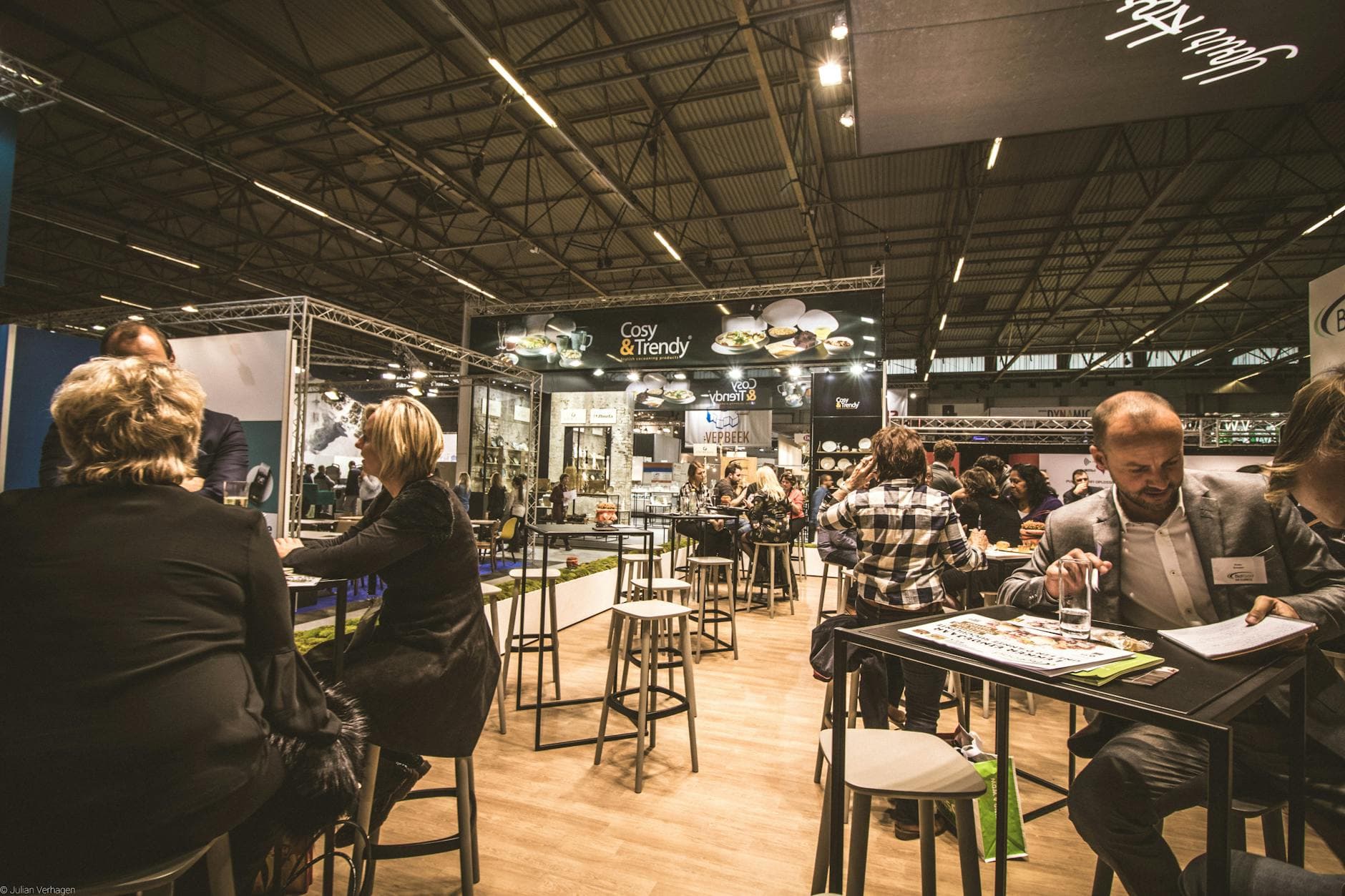 Food and beverage trade show floor with branded booths and visitors.