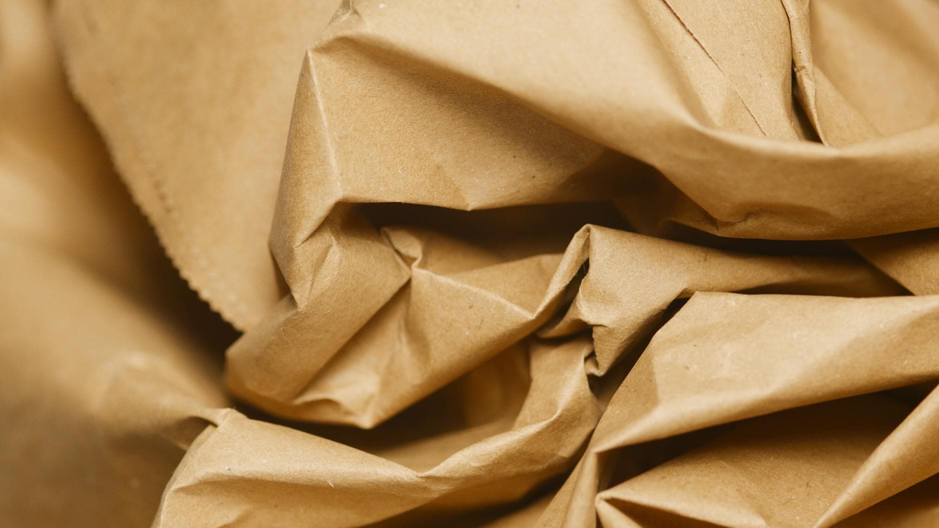 Stacked kraft paper rolls and packaging material samples in a printing studio.